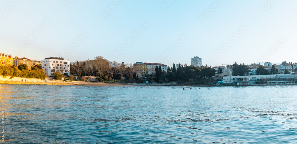 Popular beach of Bacvice in Split, Croatia. Early morning sunrise , empty beach on a cold day. Beautiful blue sky and ocean. Panorama wide shot with the whole surrounding area