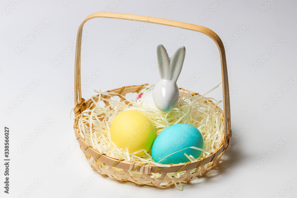 Easter eggs and bunny in a basket isolated on white background. Close-up Easter eggs and bunny in a basket isolated on white background. Close-up