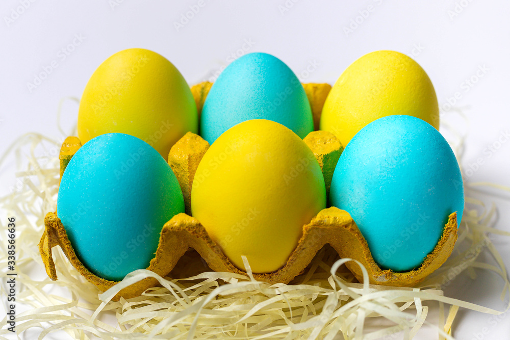 Easter eggs in yellow paper egg tray isolated on white background. Close-up Easter eggs in yellow paper egg tray isolated on white background. Close-up