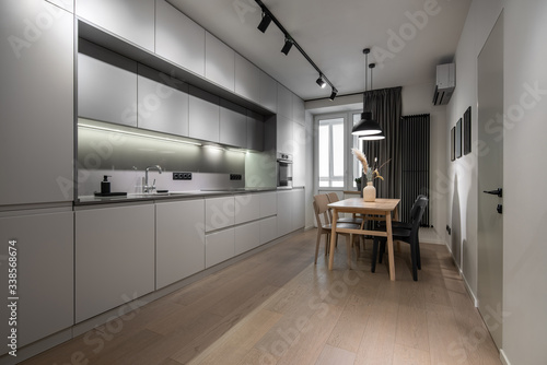 Interior of illuminated modern kitchen with white walls