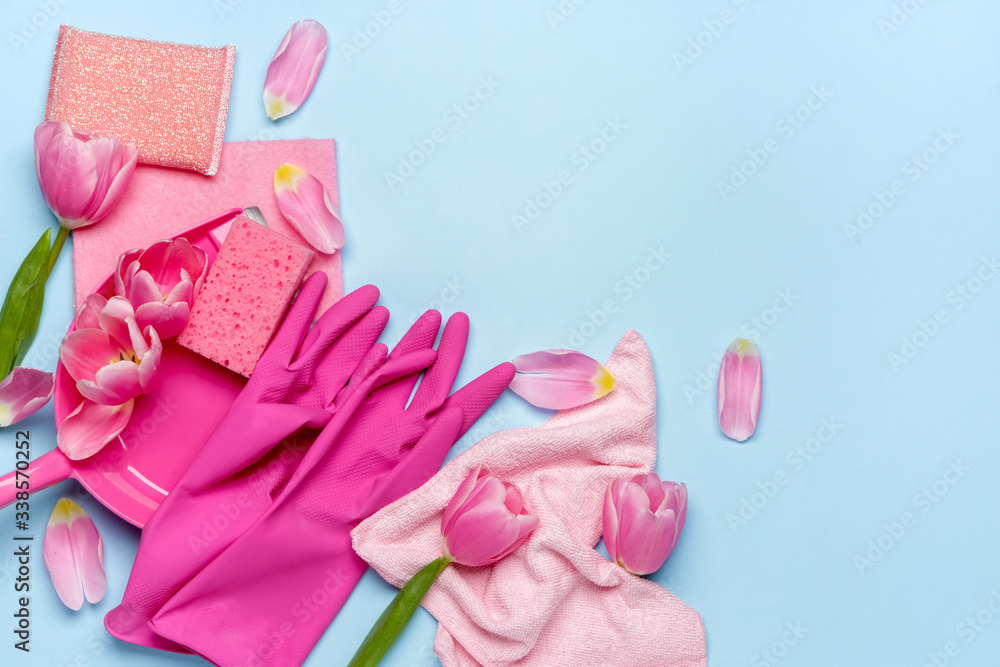 Set of cleaning supplies and spring flowers on color background