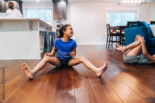 Girls dying of laughter on living room floor photo