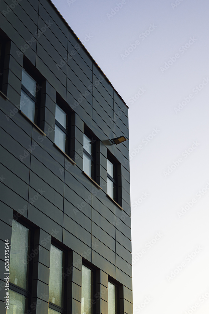 Office building facade with windows reflects the sunset. Office building facade with windows reflects the sunset.