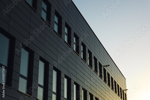 Office building facade with windows reflects the sunset.