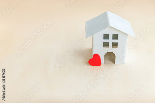 Miniature toy model house with red heart on wooden backdrop. Eco Village abstract environmental background. Real estate mortgage property insurance sweet dream home ecology concept