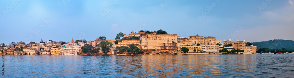Panorama of famous romantic luxury Rajasthan indian tourist landmark - Udaipur City Palace on sunset with cloudy sky. Udaipur, India