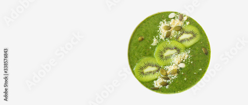 Green smothie decorated with kivi and nuts isolated on white background. Flat lay, top view