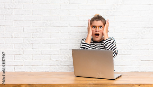  looking unpleasantly shocked, scared or worried, mouth wide open and covering both ears with hands photo