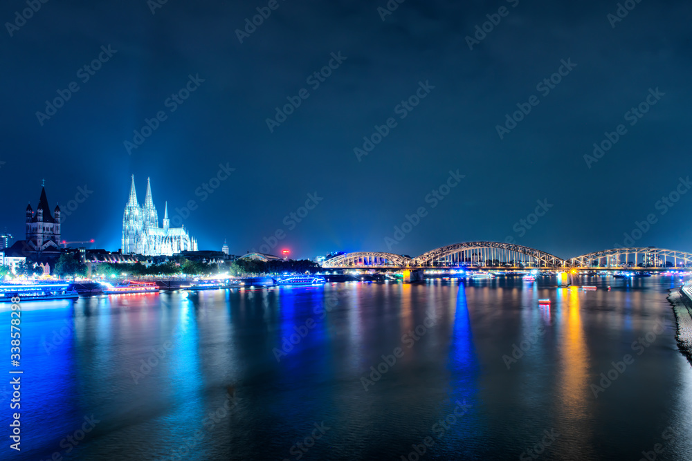 Fototapeta premium Skyline von Köln mit Kölner Dom und Hohenzollernbrücke bei Nach, Panorama of Cologne in Germany at sunset, cityscape by the Rhine.