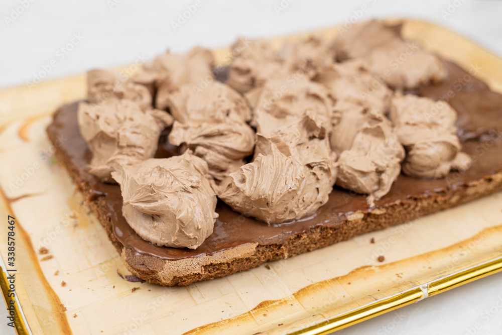 Fototapeta premium Chocolate cream on the cake. Preparing chocolate cake