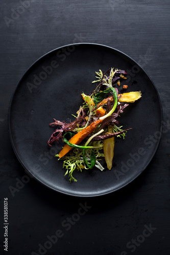 Overhead view of roasted carrots and frisee salad served on plate