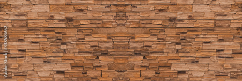 Background Modern building facade made of decorative stone  panorama. Brick or stone wall texture  banner. Texture of the stone surface.