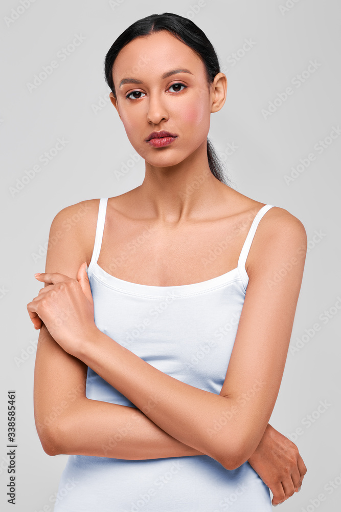 Portrait of cute afro-american girl with fresh healthy skin and crossed hands Portrait of cute afro-american girl with fresh healthy skin and crossed hands
