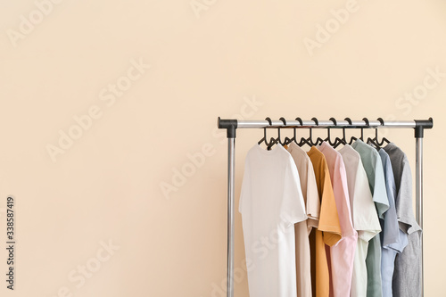 Wallpaper Mural Rack with modern clothes on color background
