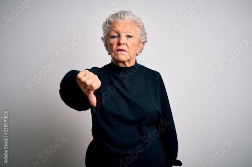 Senior beautiful woman wearing casual black sweater standing over isolated white background looking unhappy and angry showing rejection and negative with thumbs down gesture. Bad expression. © Krakenimages.com