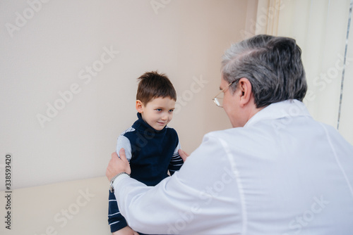 A young boy is listened to and treated by an experienced doctor in a modern clinic. A virus, and an epidemic