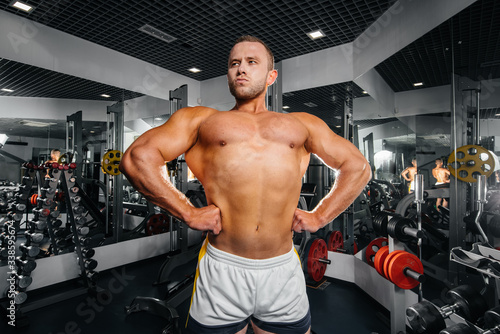 A young athletic guy is engaged in fitness in the gym. Fitness, bodybuilding