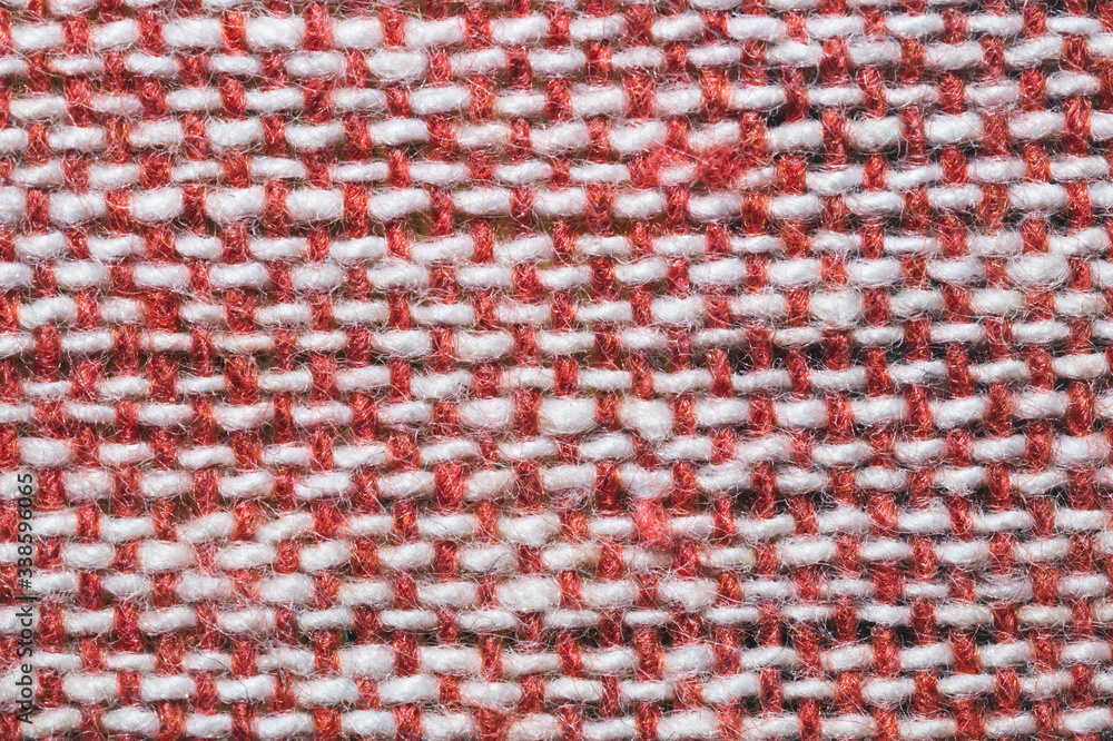 Fabric macro texture. knitted textile. woven background. woolen material. weaving of red and white threads close up