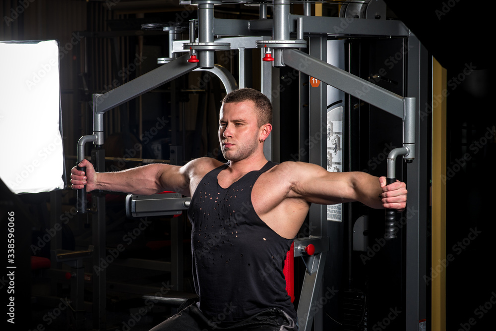 A young athletic guy is engaged in fitness in the gym. Fitness, bodybuilding A young athletic guy is engaged in fitness in the gym. Fitness, bodybuilding