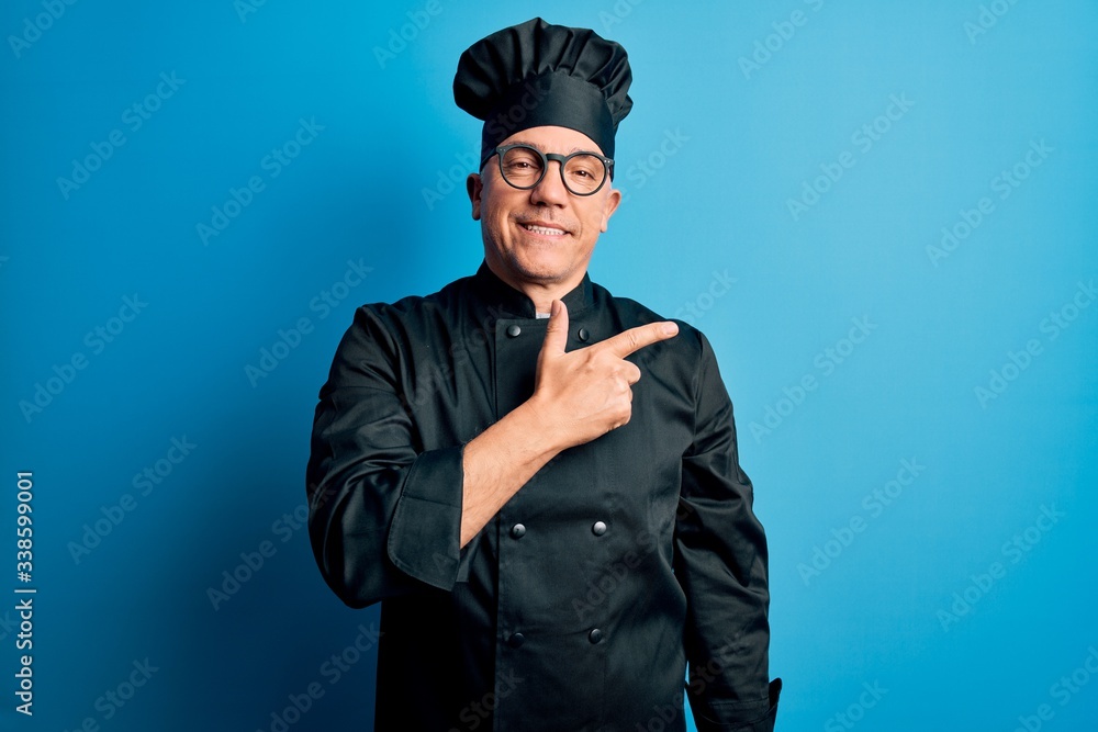 Middle age handsome grey-haired chef man wearing cooker uniform and hat cheerful with a smile on face pointing with hand and finger up to the side with happy and natural expression Middle age handsome grey-haired chef man wearing cooker uniform and hat cheerful with a smile on face pointing with hand and finger up to the side with happy and natural expression