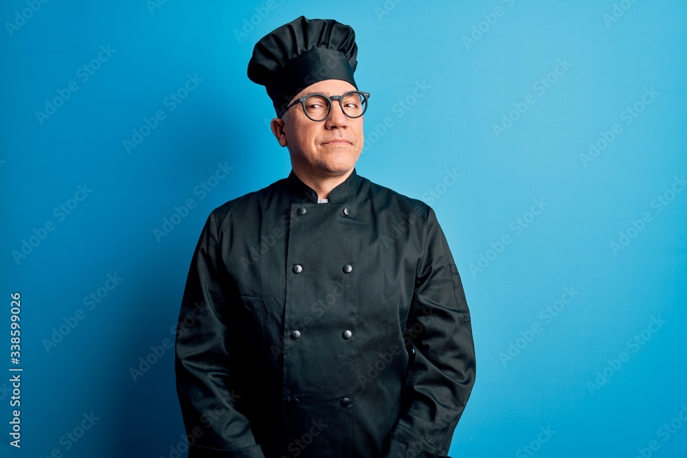 Middle age handsome grey-haired chef man wearing cooker uniform and hat smiling looking to the side and staring away thinking. Middle age handsome grey-haired chef man wearing cooker uniform and hat smiling looking to the side and staring away thinking.