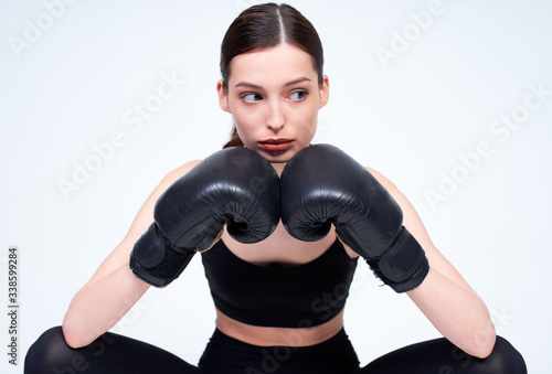 Young sports girl with boxing gloves on a white background.