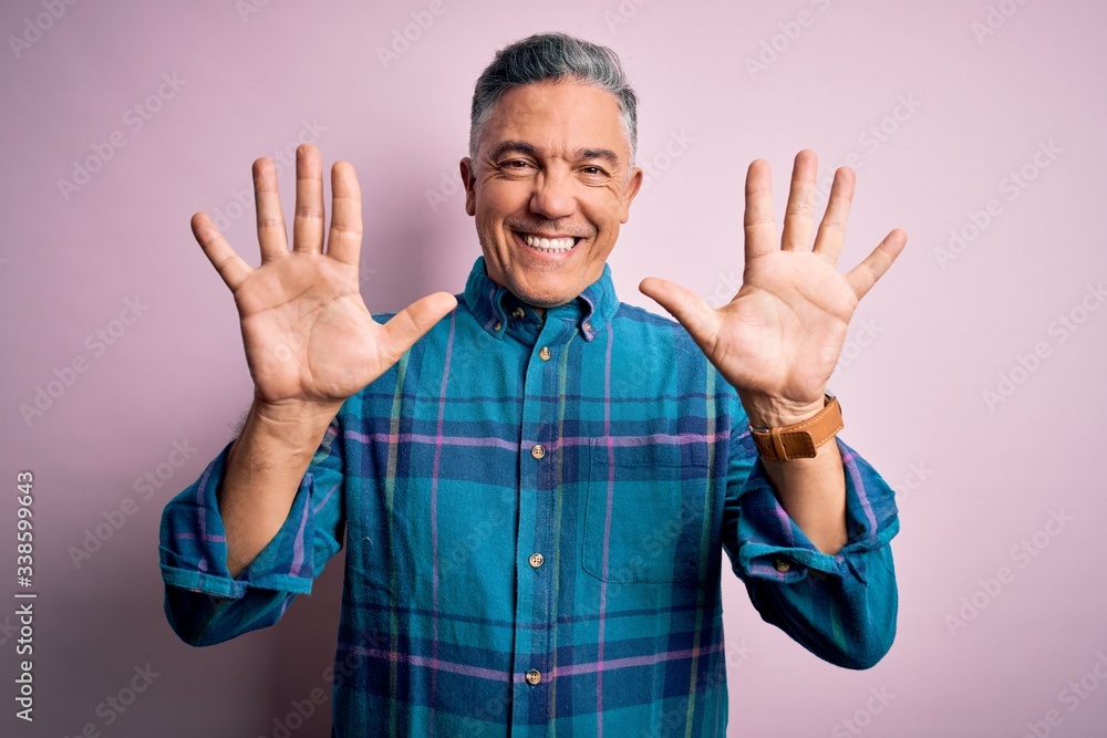 Middle age handsome grey-haired man wearing casual shirt over isolated pink background showing and pointing up with fingers number ten while smiling confident and happy. Middle age handsome grey-haired man wearing casual shirt over isolated pink background showing and pointing up with fingers number ten while smiling confident and happy.