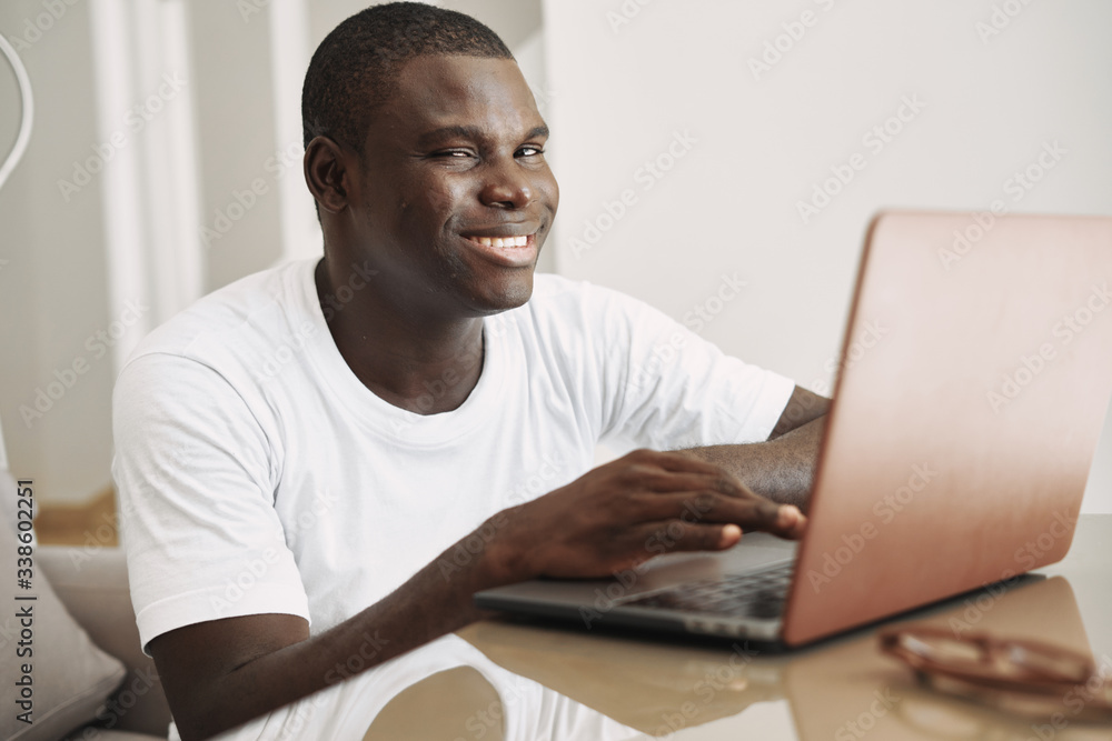 A man of African appearance at home in front of a laptop A man of African appearance at home in front of a laptop