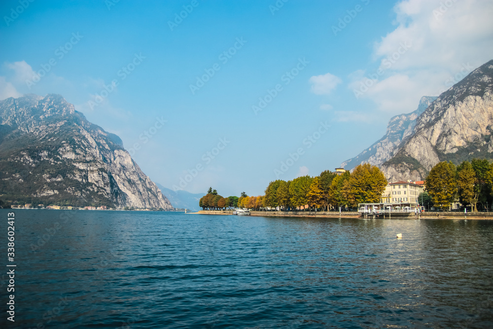 Beautiful sunny day on Lake Como and the small town of Lecco in Lombardy, Northern Italy. Italian traditional lake village, travel concept.