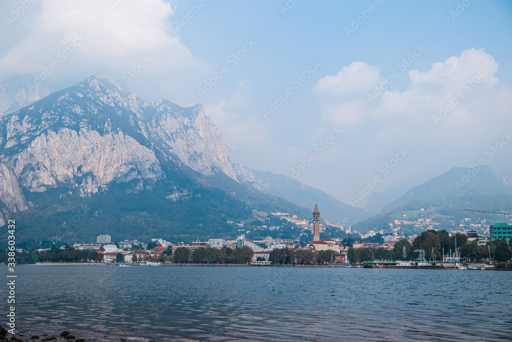 Lake Como and the small town of Lecco in Lombardy, Northern Italy. View of Bell tower of the Basilica of St Nicholas and Bergamo Alps.