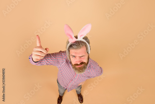 Easter man points finger on copy space. Sale. Discount. Season sales. Happy Easter. Man in bunny ears. Rabbit man. Man in rabbit ears. Springtime. Holidays. Preparation for Easter.