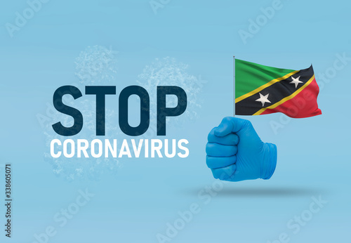 COVID-19 Visual concept - hand-text Stop Coronavirus  hand-gesture versus virus infection  clenched fist holds flag of Saint Kitts and Nevis. Pandemic 3D illustration.