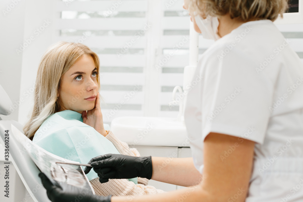Obraz premium Female dentist in dental office talking with female patient and preparing for treatment