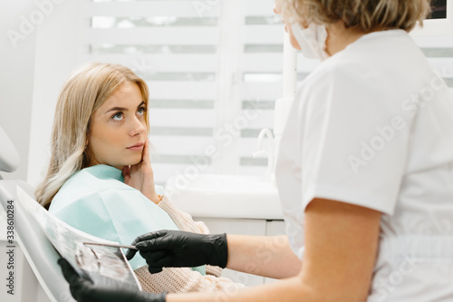 Female dentist in dental office talking with female patient and preparing for treatment © dsheremeta