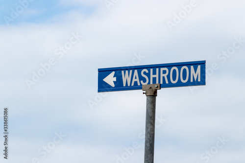 outdoor blue and white sign pointing the direction to the washroom