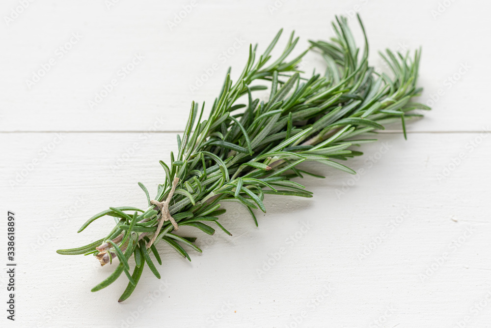 Isolated Bunch of Rosemary Sprigs Tied with Twine on White Wood Background Isolated Bunch of Rosemary Sprigs Tied with Twine on White Wood Background