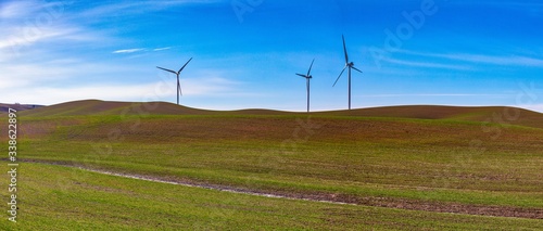Wind power turbines at ease on a plowed field 
