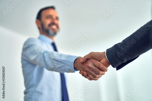 Businessmen standing together shaking hands for agreement at the office