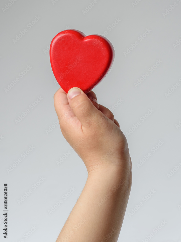 Kid hands holding red heart - symbol of the love and care. Kid hands holding red heart - symbol of the love and care.
