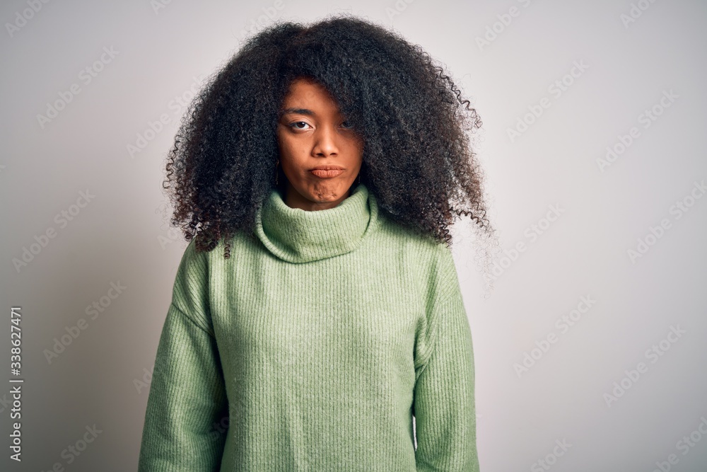 Young beautiful african american woman with afro hair wearing green winter sweater depressed and worry for distress, crying angry and afraid. Sad expression. Young beautiful african american woman with afro hair wearing green winter sweater depressed and worry for distress, crying angry and afraid. Sad expression.