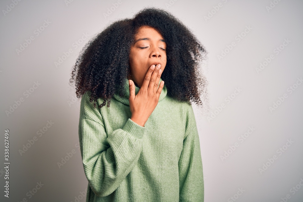 Young beautiful african american woman with afro hair wearing green winter sweater bored yawning tired covering mouth with hand. Restless and sleepiness. Young beautiful african american woman with afro hair wearing green winter sweater bored yawning tired covering mouth with hand. Restless and sleepiness.