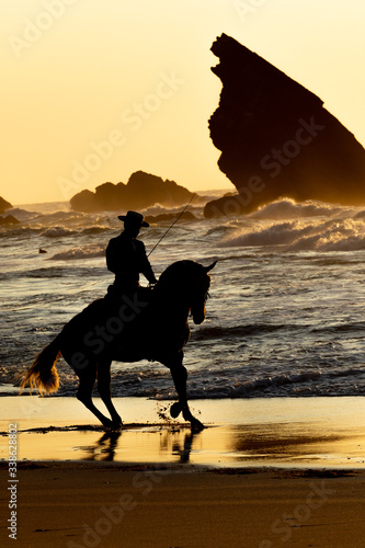 Foto Riding a Lusitano horse at the beach during sunset