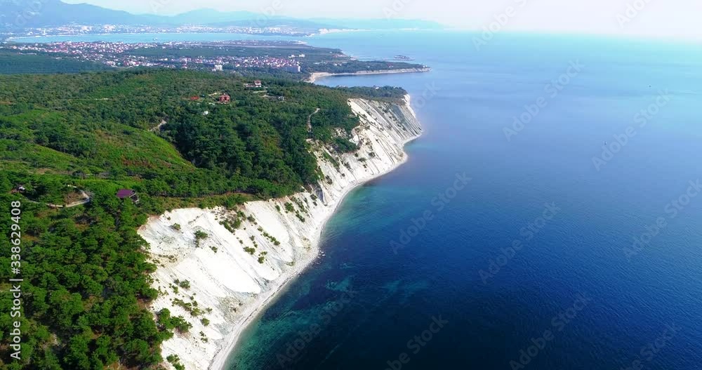 Flight along the rocky coast of the sea and near the resort of Gelendzhik, Black sea. High layered rocks covered with trees. In the background, the Blue Bay, Gelendzhik, the Caucasus mountains. Clear Flight along the rocky coast of the sea and near the resort of Gelendzhik, Black sea. High layered rocks covered with trees. In the background, the Blue Bay, Gelendzhik, the Caucasus mountains. Clear