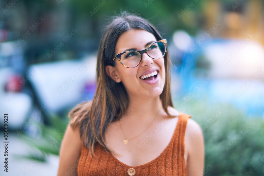 Young beautiful woman smiling happy and confident. Standing with smile on face at the town street