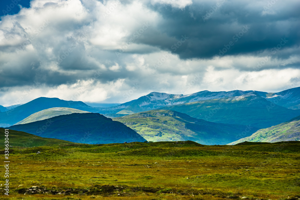 Obraz premium Light dapples hills in Scottish Highlands on cloudy day