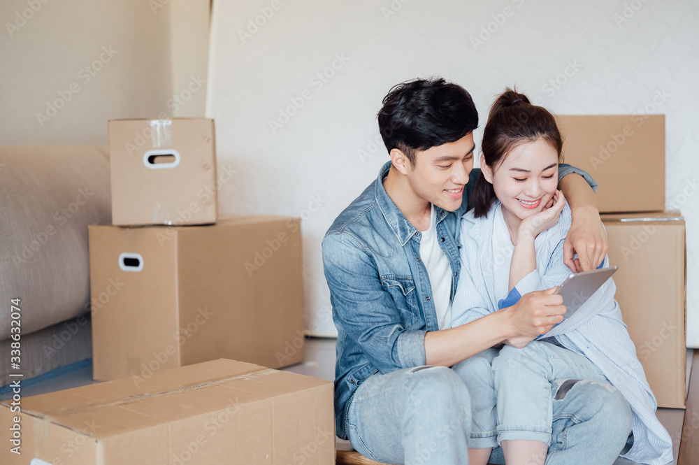 Young Asian couple using tablet computers in new home Young Asian couple using tablet computers in new home