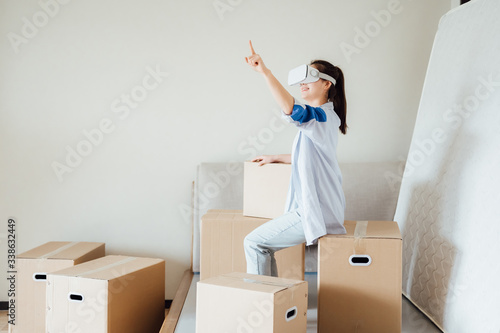 Asian young girl using VR glasses at home