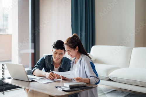 Young Asian couple at home using computer