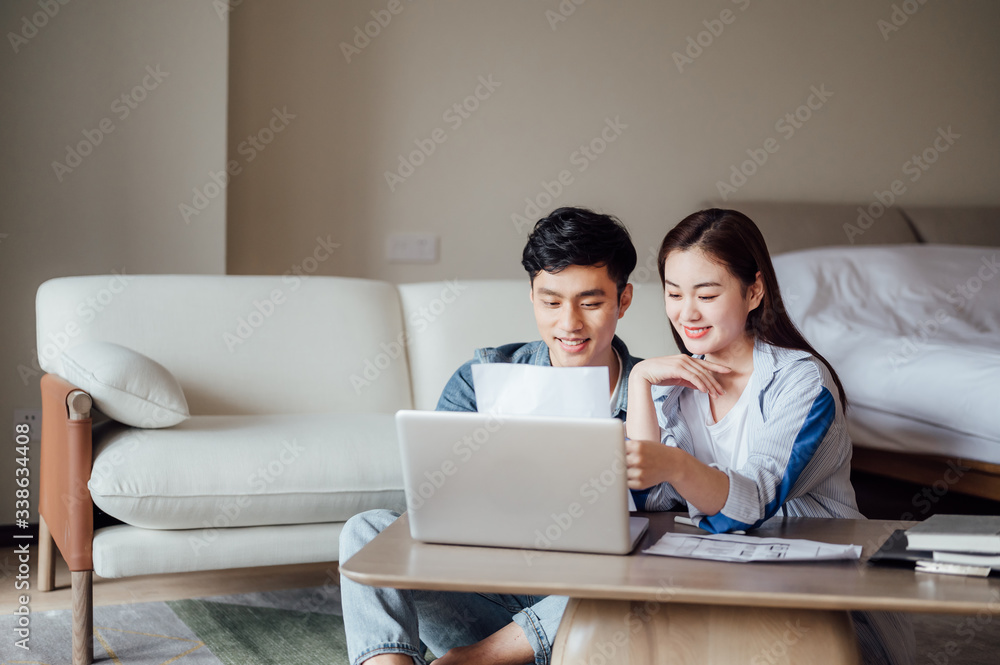 Young Asian couple at home using computer Young Asian couple at home using computer