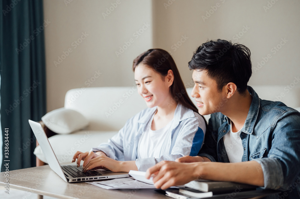 Young Asian couple at home using computer Young Asian couple at home using computer